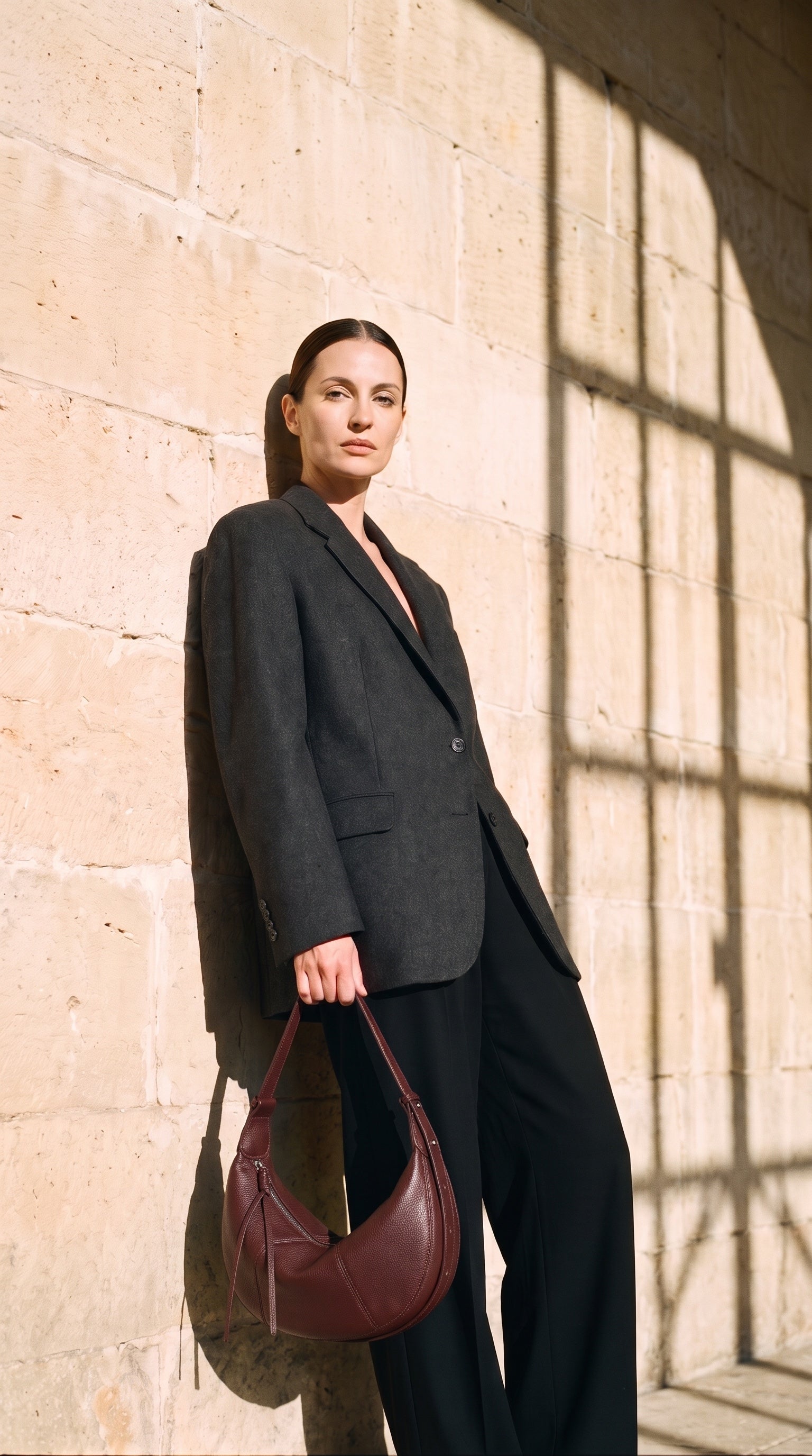 Sac CHLOE porté par le mannequin devant un mur de pierre
