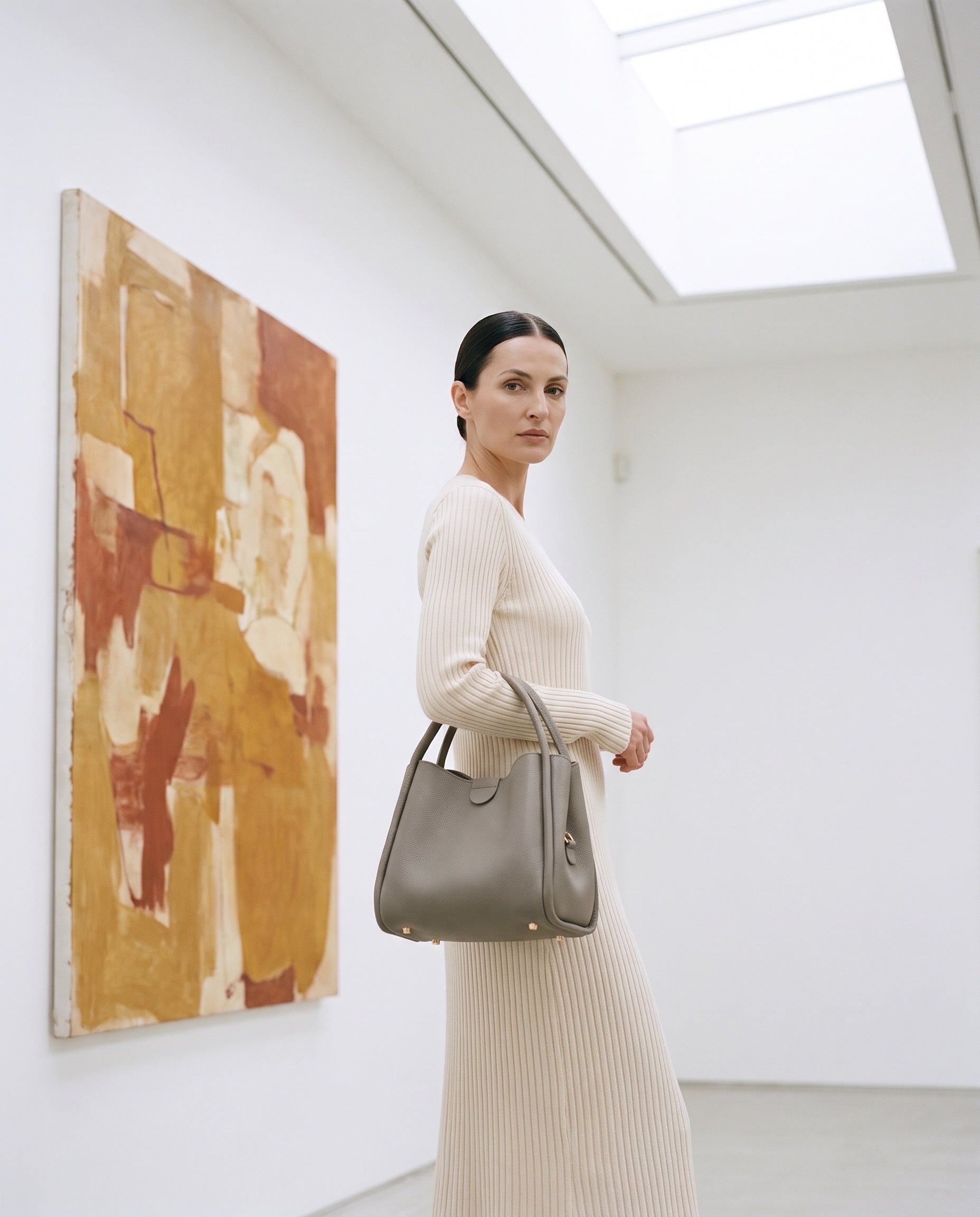 Sac CLARA porté par le mannequin dans une galerie d'art
