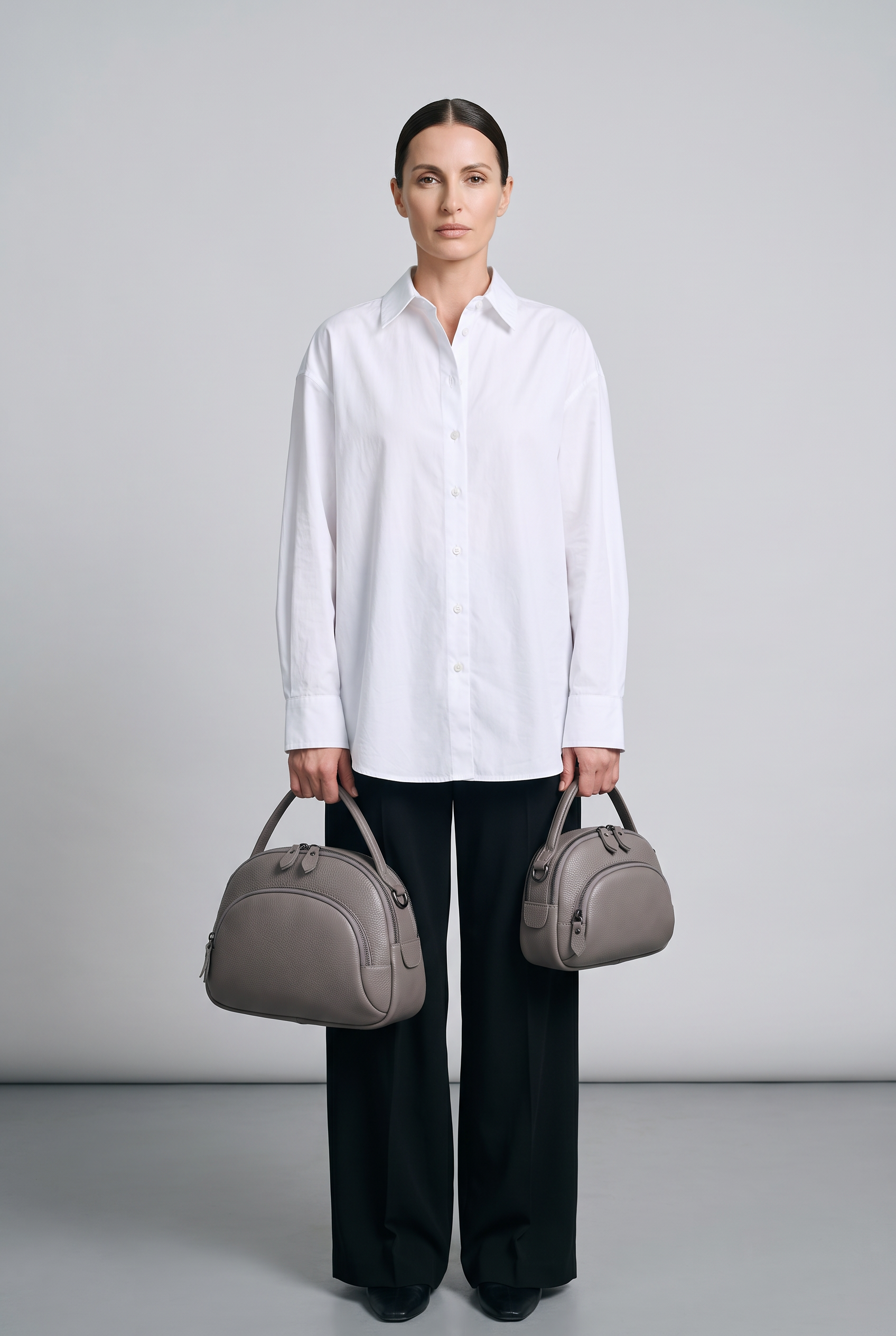 Sac CLEO gris, grand et petit modèle portés à la main
