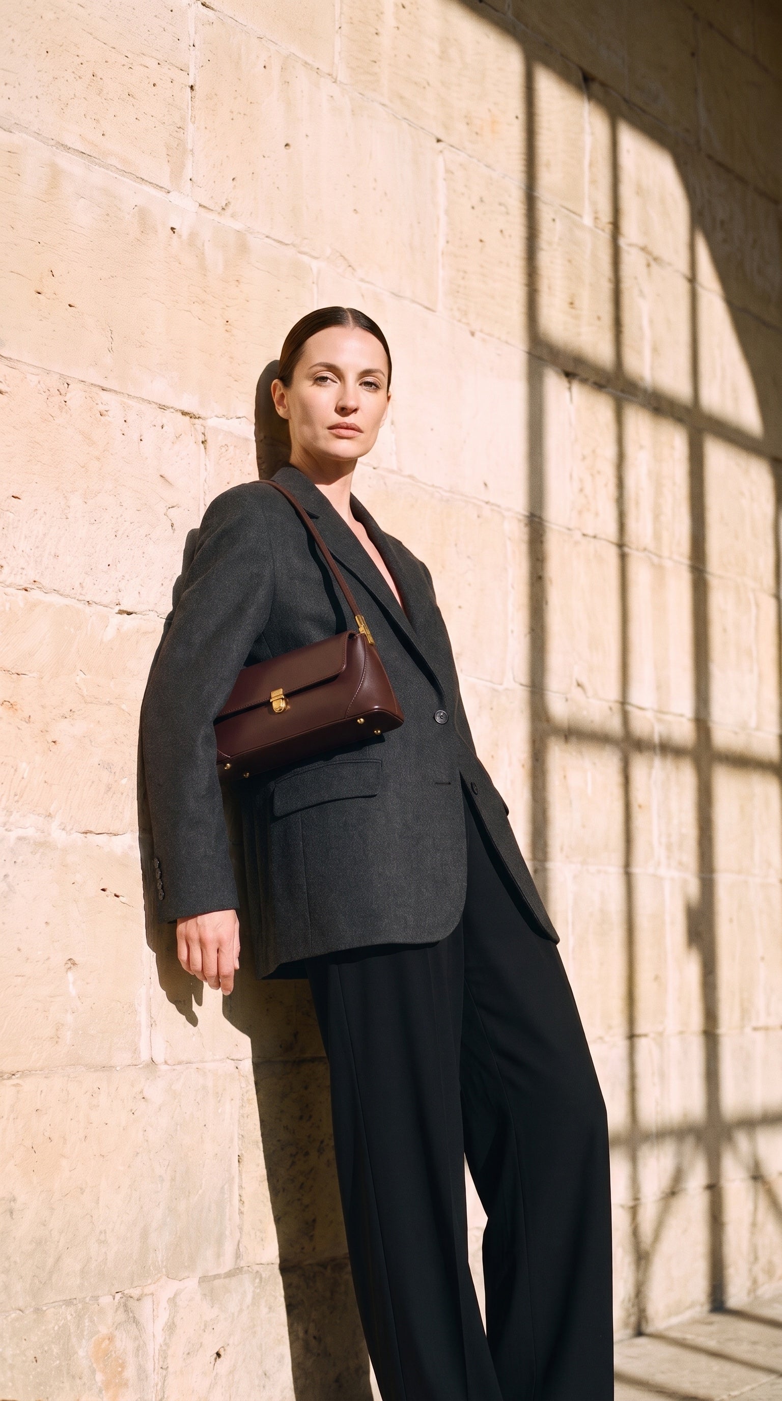 Sac SOFIA porté par le mannequin devant un mur de pierre