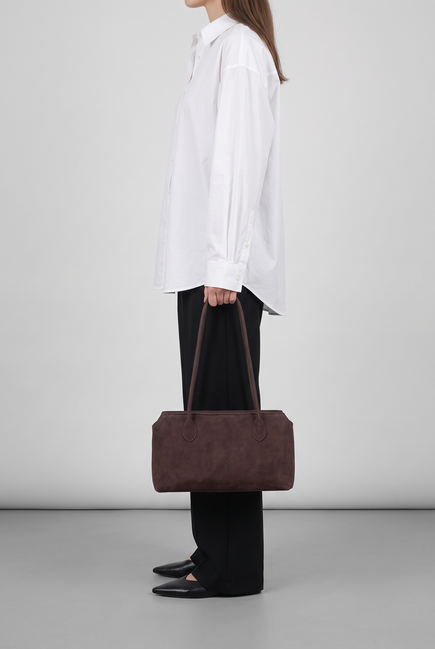 Sac AVA marron foncé, porté à la main