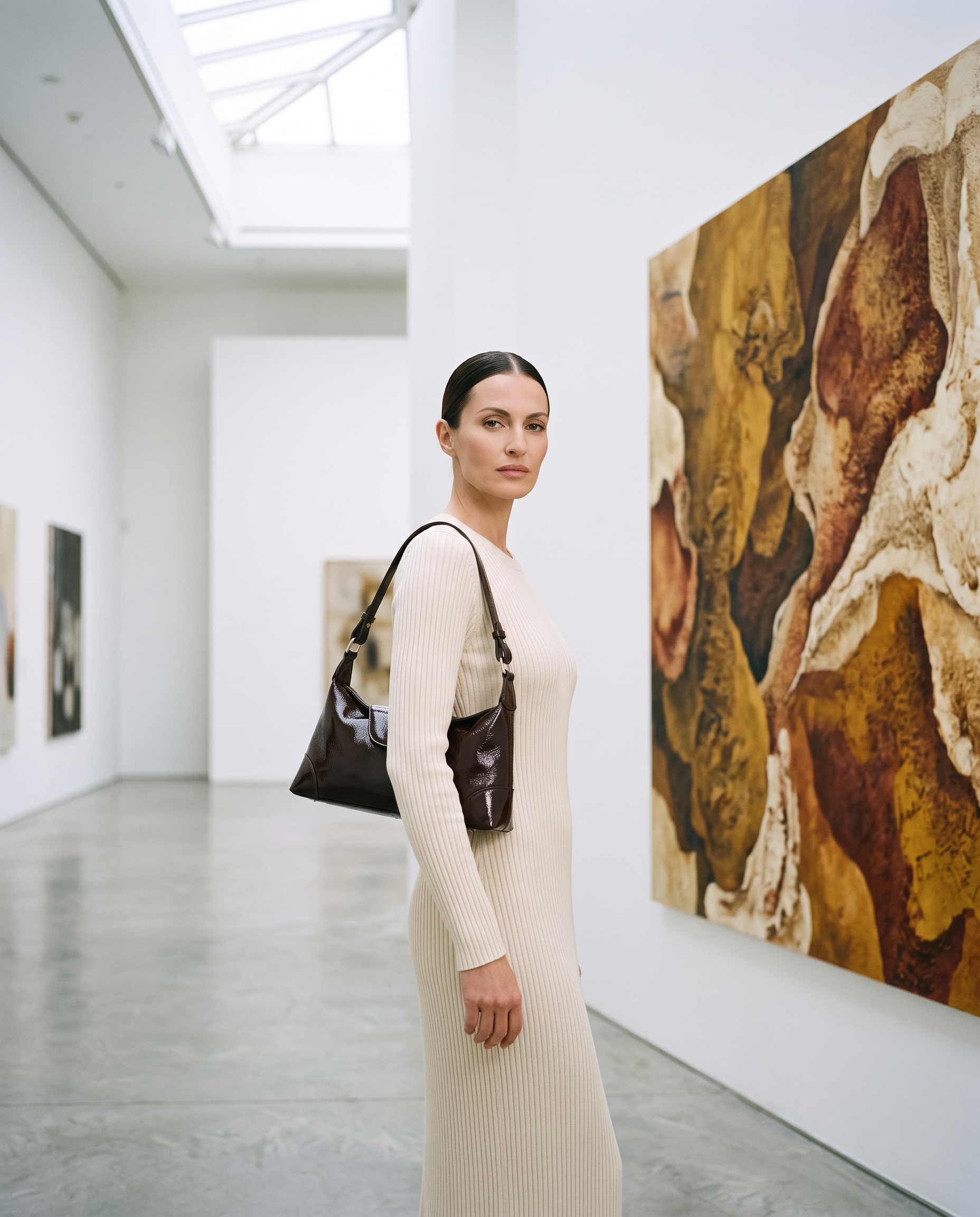 Sac JOANA marron foncé, porté dans une galerie d'art