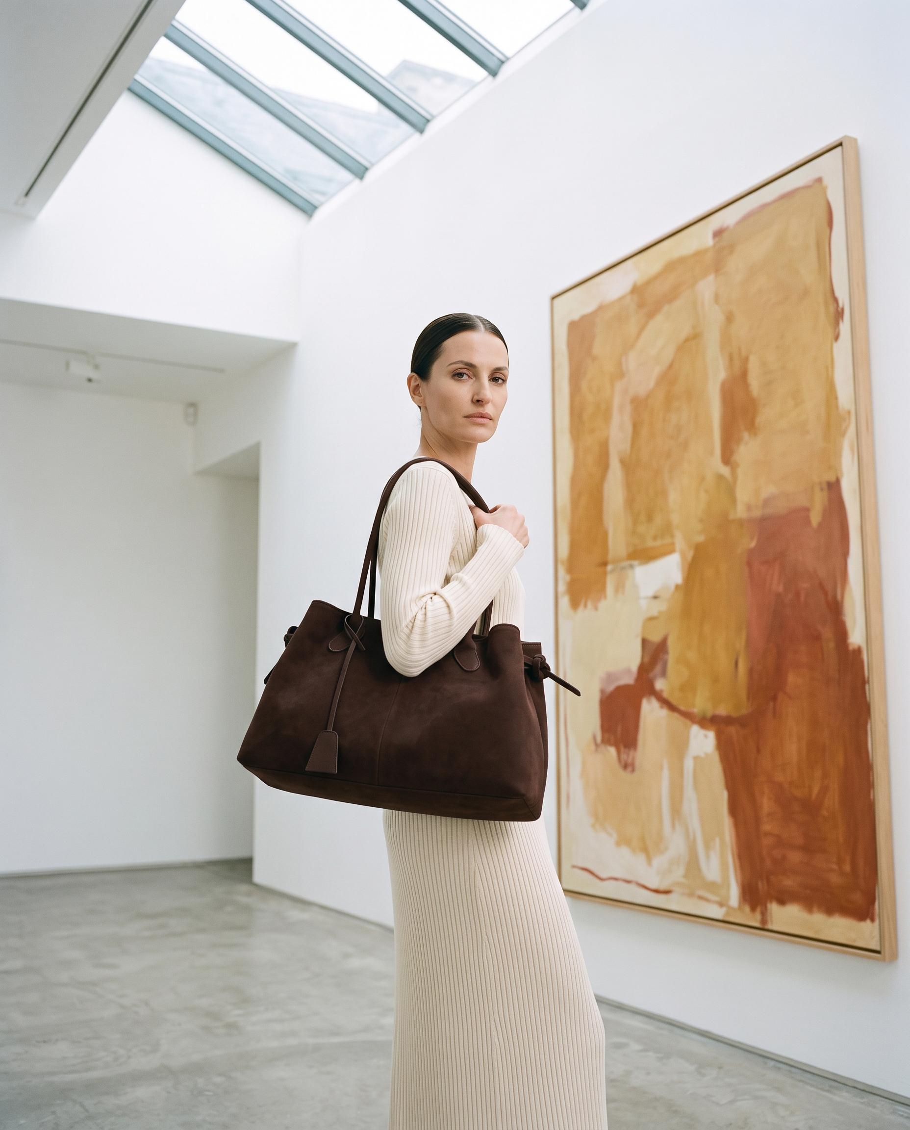 Cabas RAFAELA marron foncé, porté dans une galerie d'art