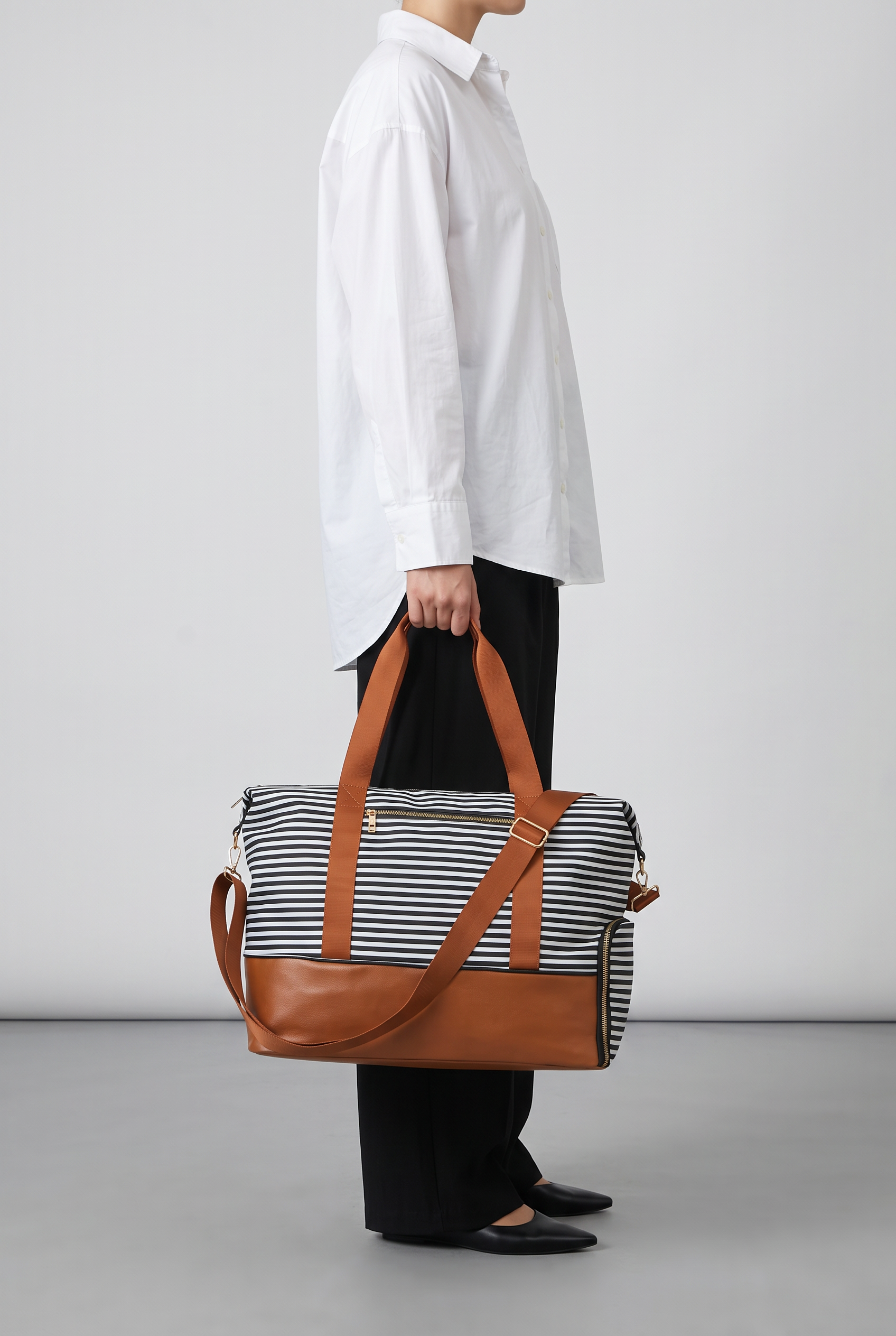 Sac de voyage LOUISE rayé noir et blanc, porté à la main