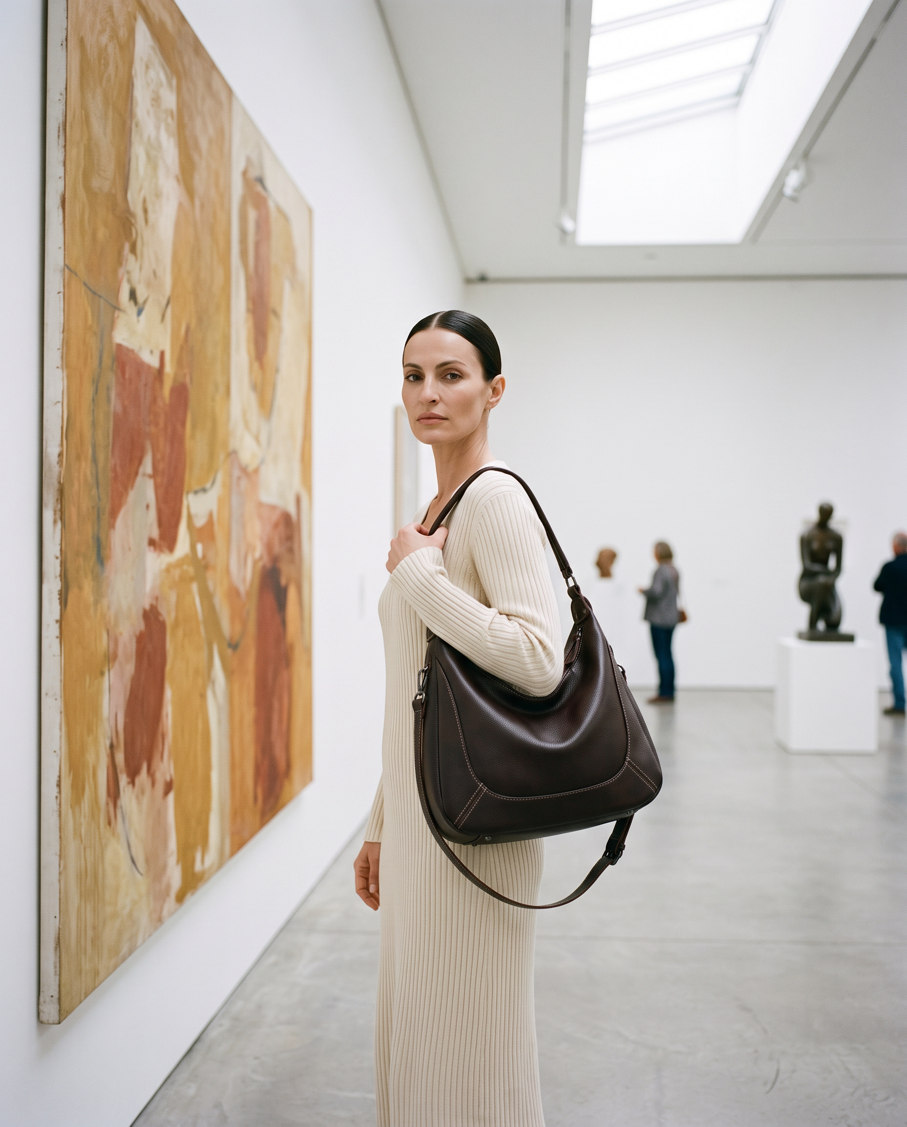 Sac LUCIE marron foncé, porté dans une galerie d'art