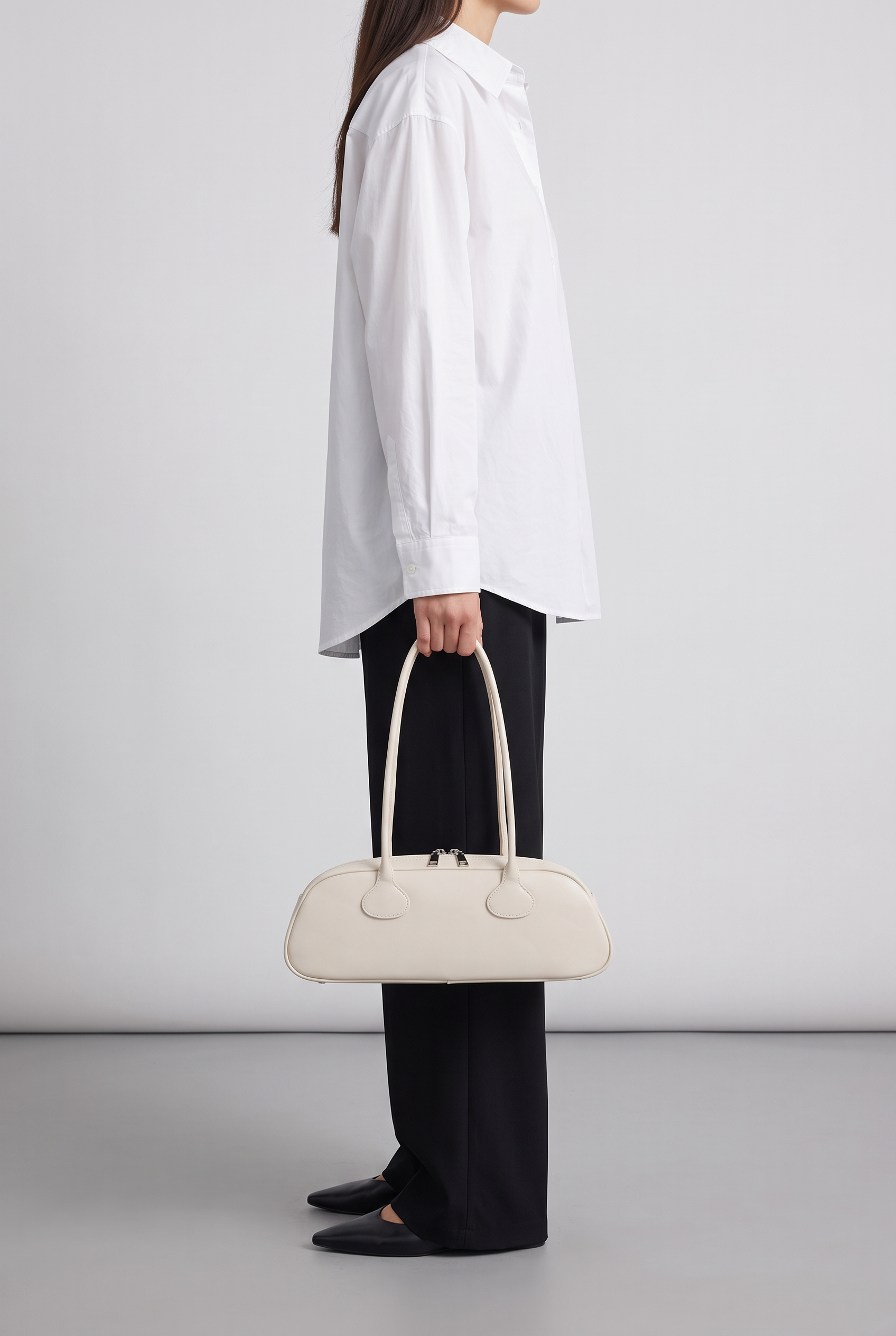 Sac baguette GRETA crème, porté à la main